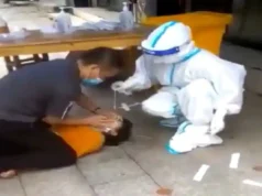 In this viral video, a Chinese woman is pinned down and forced to take a Covid test.